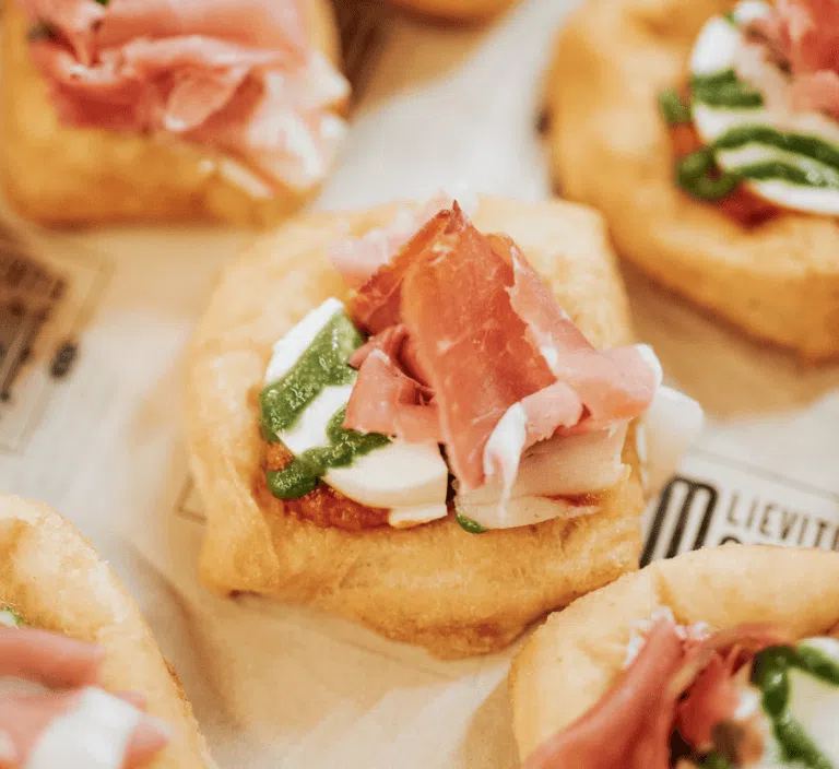 Antipasti gourmet con piccoli finger pizza con prosciutto crudo, crema di basilico e burrata